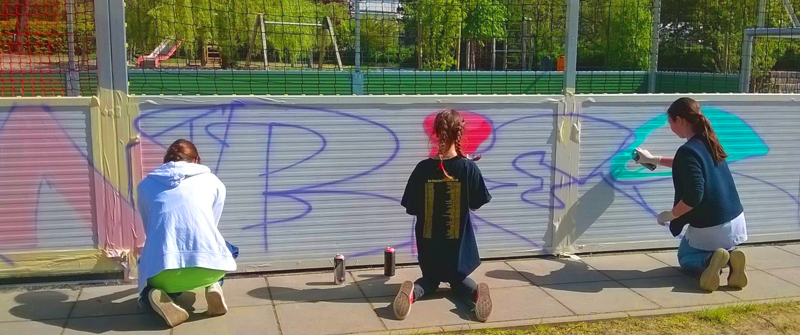 Schulsozialarbeit an der Biesalski-Schule, Förderzentrum, Förderschwerpunkt „Körperliche und motorische Entwicklung“, Grundschule und integrierte Sekundarschule, Gruppe spielender Schülerinnen gestalten ein Graffiti Schulsozialarbeit an der Biesalski-Schule, Förderzentrum, Förderschwerpunkt „Körperliche und motorische Entwicklung“, Grundschule und integrierte Sekundarschule, Gruppe spielender Schülerinnen gestalten ein Graffiti